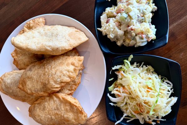 Fried, meat-filled khuushuur pastries with two kinds of chilled salad.