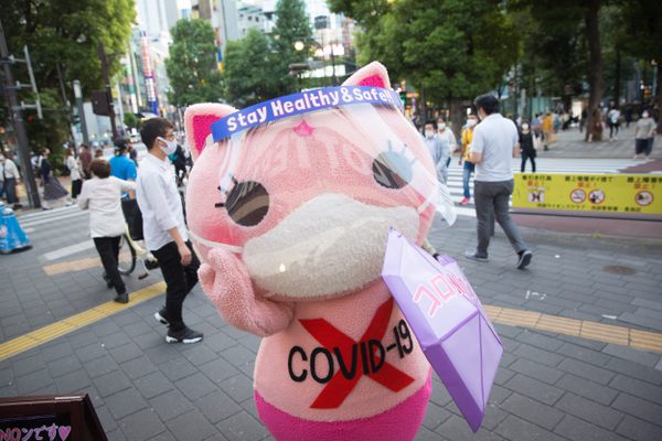 Koronon hands out face masks to encourage people to stay vigilant about COVID-19.