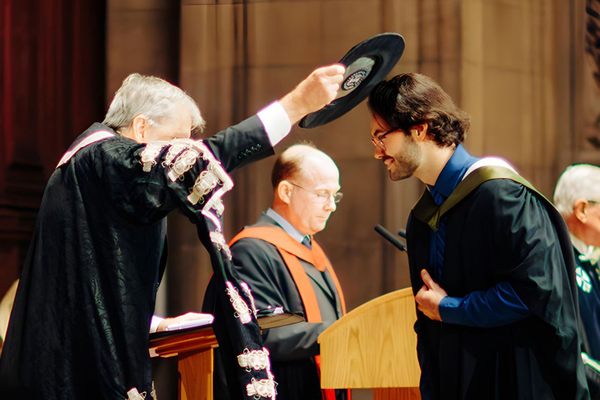 At the University of Edinburgh’s graduation ceremony, a student is tapped with the Geneva Bonnet.